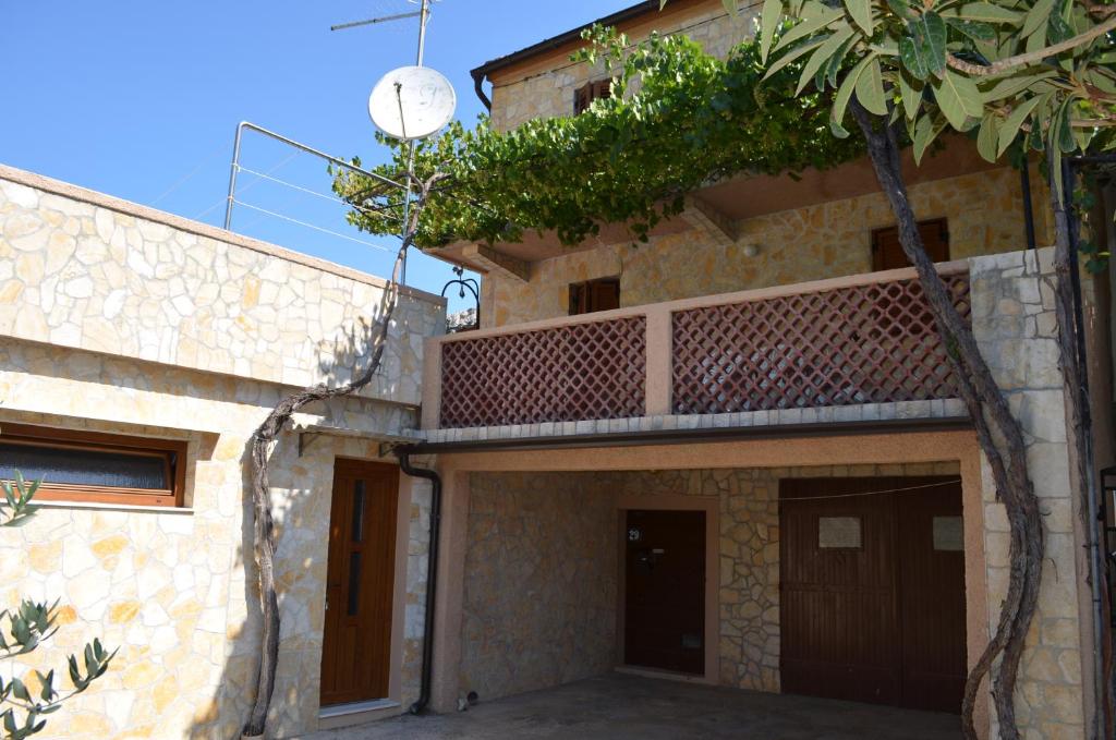 a house with a balcony on the side of it at Holiday Home Garina in Draga Bašćanska