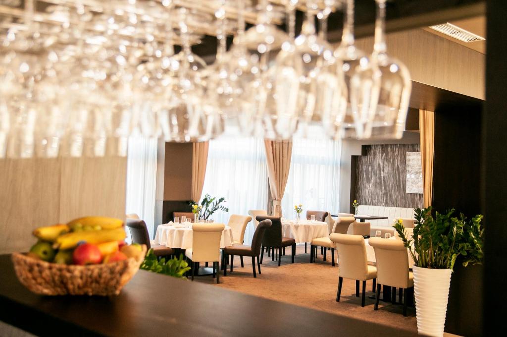 uma sala de jantar com mesas, cadeiras e copos de vinho em AZUL Hotel & Restaurant Partizánske em Partizánske