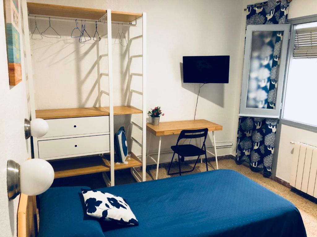 um quarto com uma cama, uma secretária e um computador em Hostal Carlos III em El Prat de Llobregat