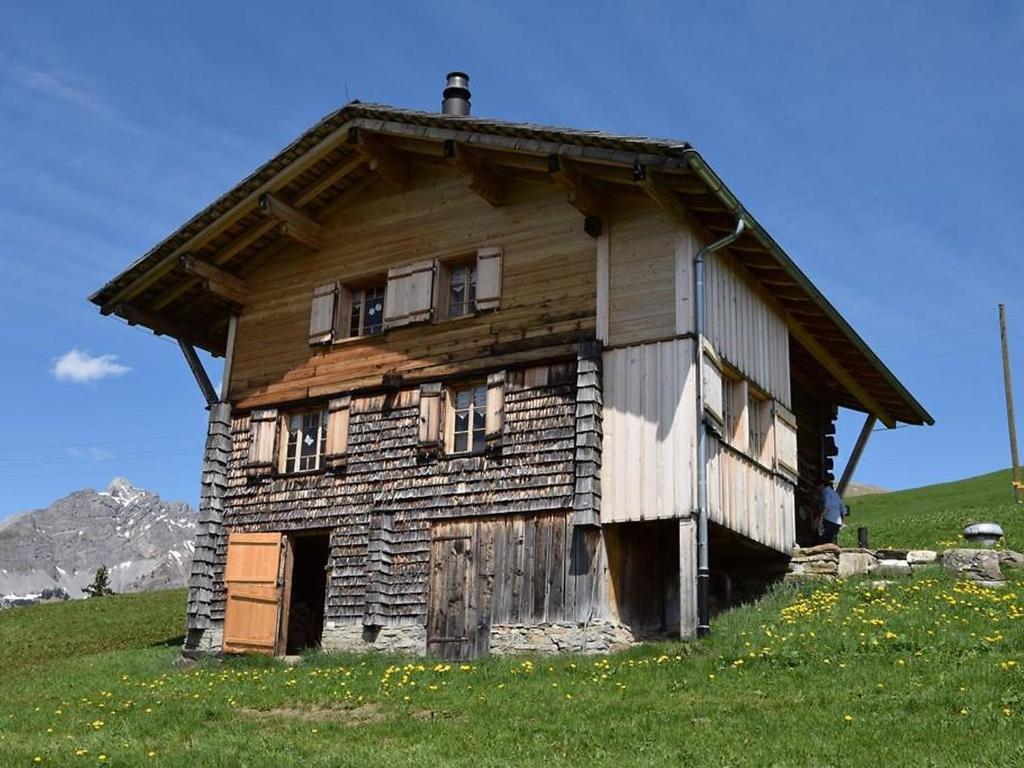 una vecchia casa in legno su una collina in un campo di Apartment Alphütte Gibelhüttli by Interhome a Giebel