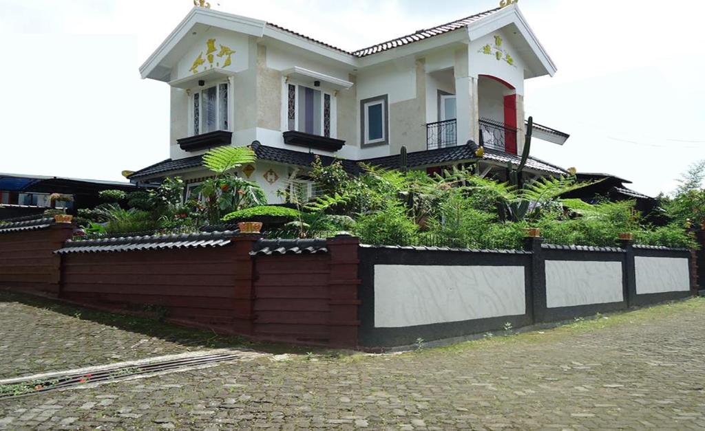 a house with a fence in front of it at Villa Cipanas in Cianjur