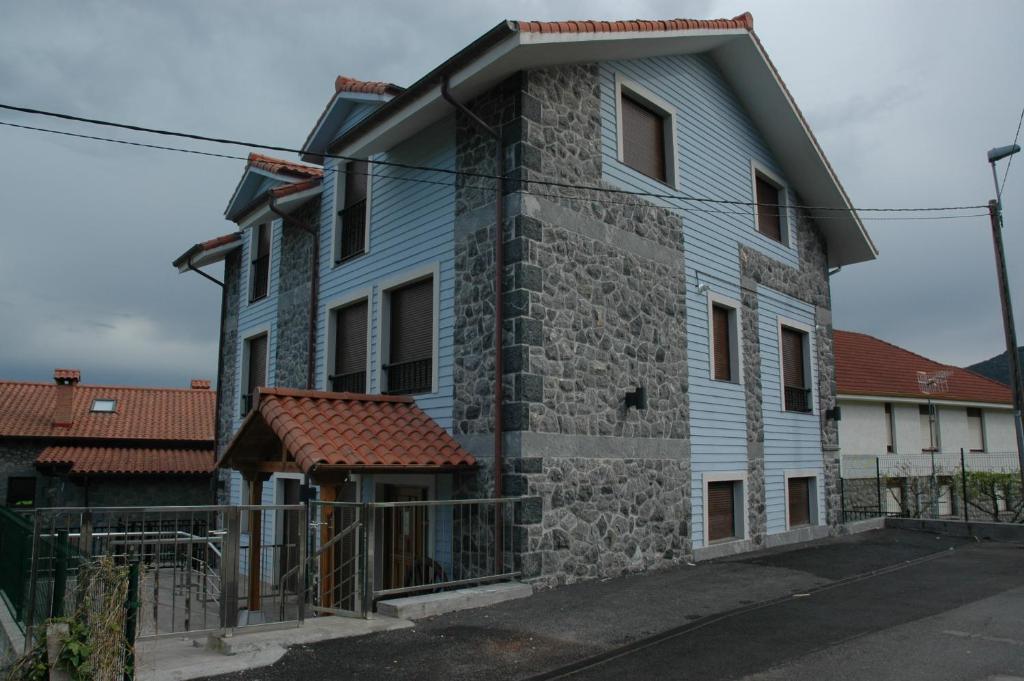 una casa azul con una pared de piedra en Apartamentos Torremar, en Isla