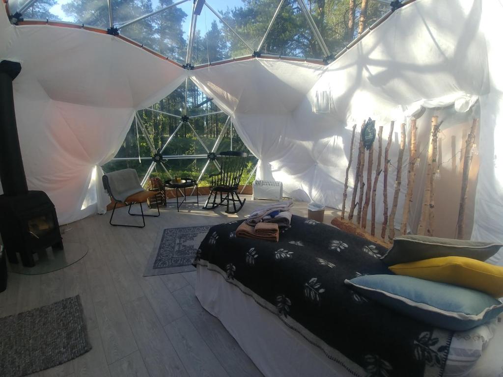 a living room with a bed in a tent at GLØD Aurora Canvas Dome in Alta