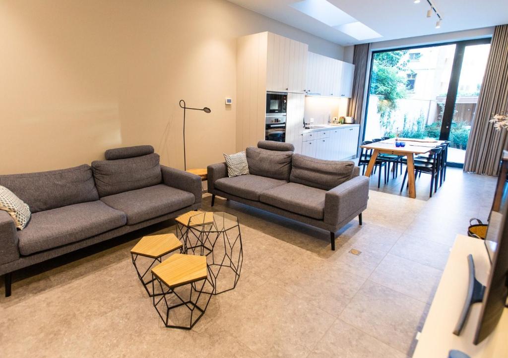 Una sala de estar con dos sofás y una mesa. en Blossom & Bloom, en Brujas