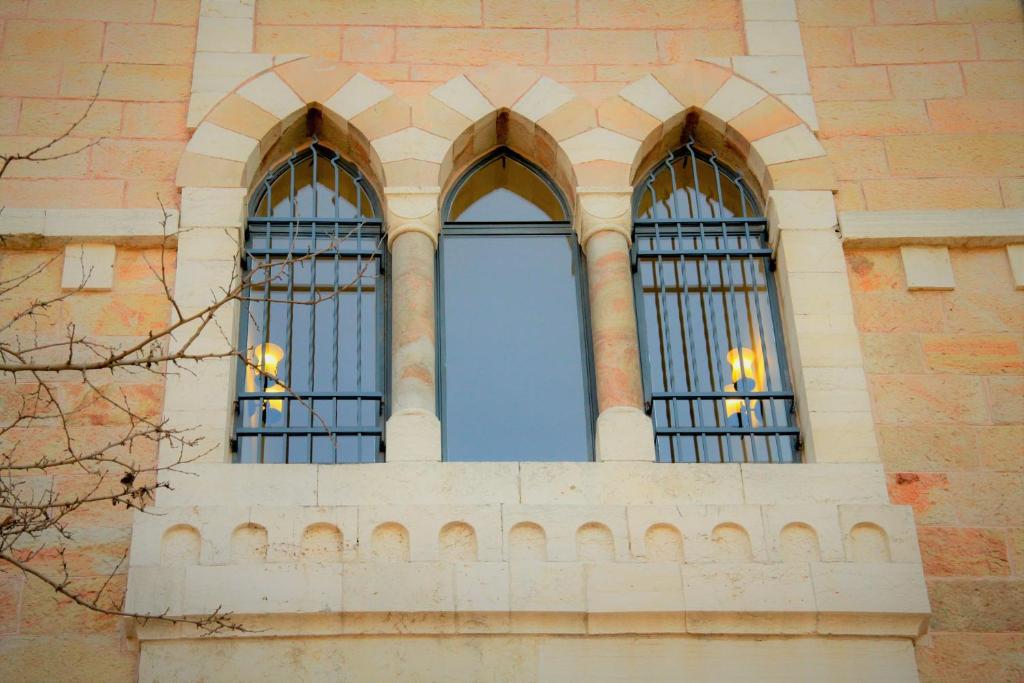 two windows on a brick building with iron bars at Villa Brown Moshava - a member of Brown Hotels in Jerusalem