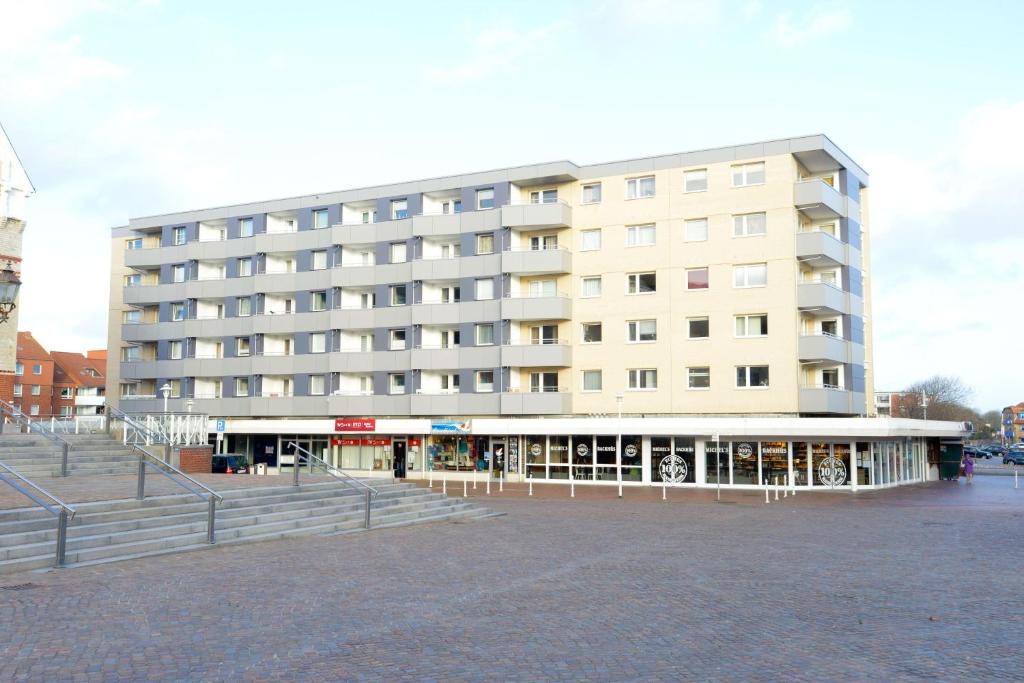 韋斯特蘭的住宿－App-Syltliebe-Haus-Ankerlicht-Whg-70，前面有楼梯的大型白色建筑