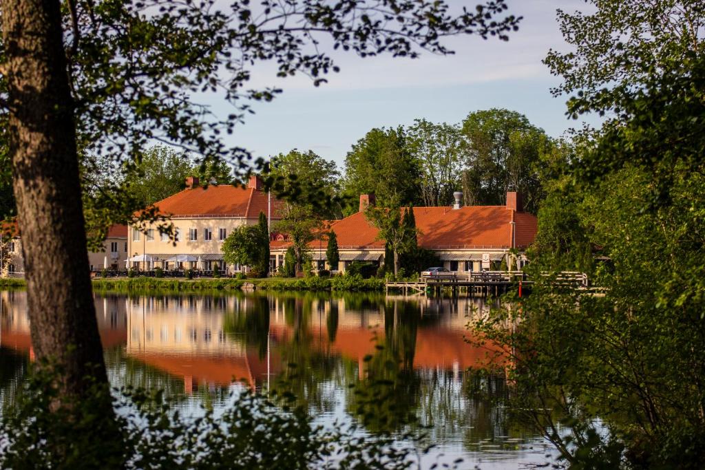 a couple of buildings sitting next to a lake at Åsby Hotell in Hallstahammar