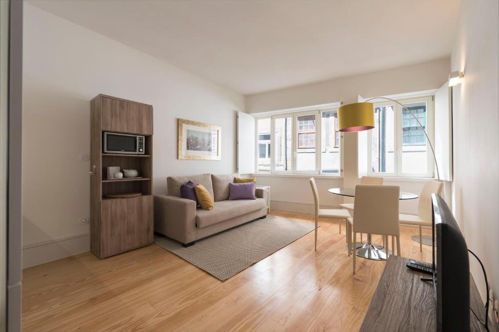 - un salon avec une table et un canapé dans l'établissement BmyGuest - Villa Lóios Terrace Apartment, à Porto