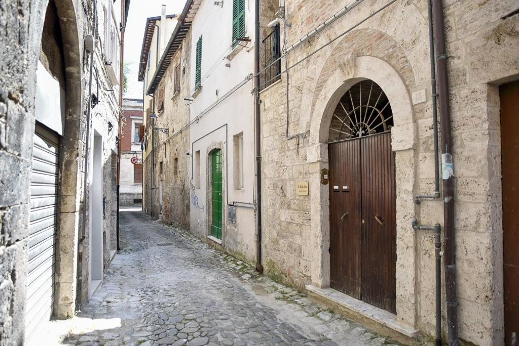 un callejón con una puerta marrón en un edificio antiguo en Patty's house, en Ascoli Piceno