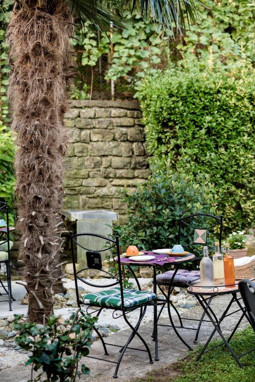 a table and chairs in a yard with a stone wall at Miracolo di Mare Retro in Piran