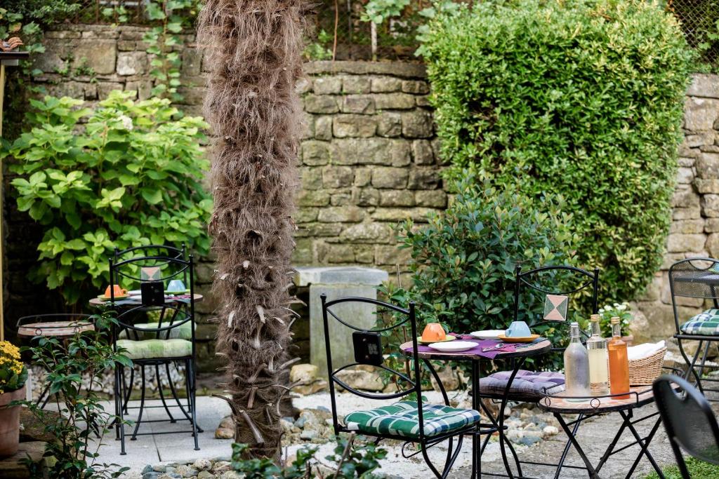 a patio with tables and chairs in a garden at Miracolo di Mare Retro in Piran