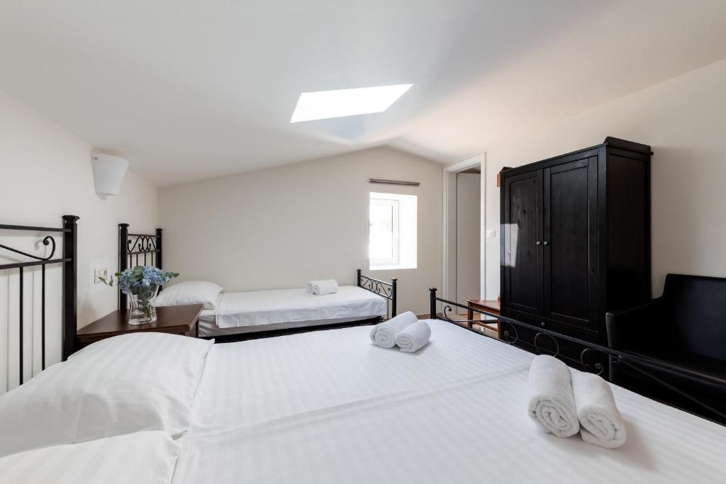 a bedroom with two beds with white sheets and a tv at Miracolo di Mare Retro in Piran