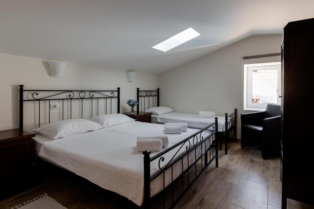a bedroom with two beds with white sheets and a window at Miracolo di Mare Retro in Piran