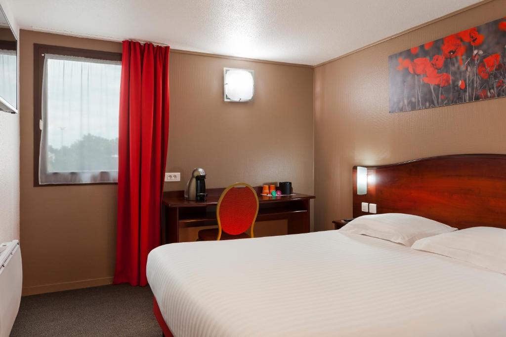 sypialnia z łóżkiem, biurkiem i czerwoną zasłoną w obiekcie Hôtel Arras Sud w mieście Arras