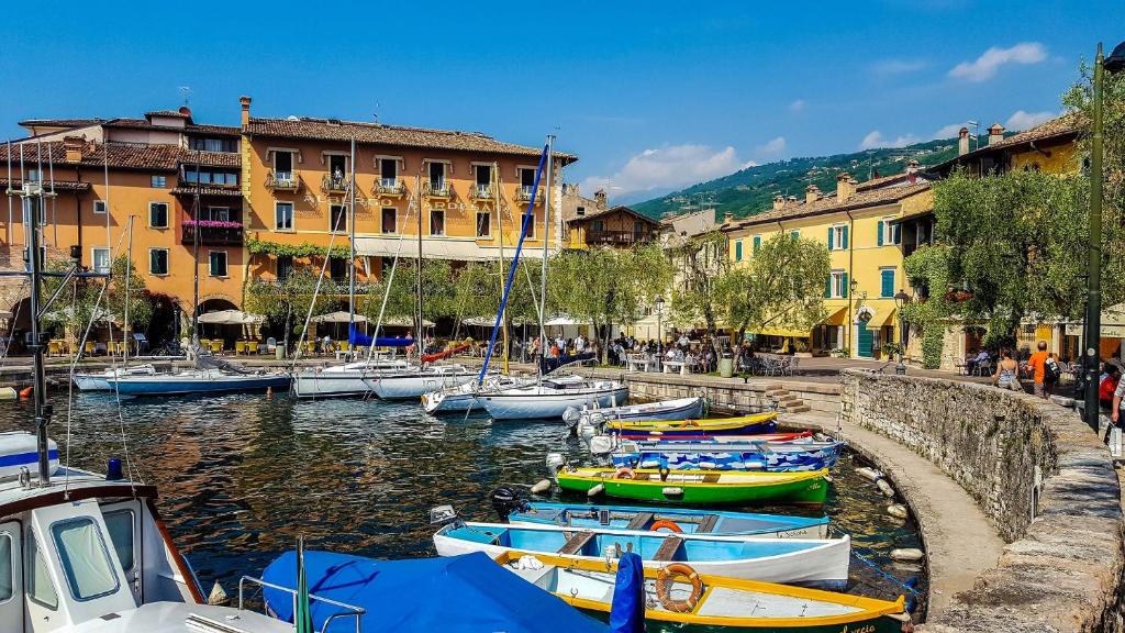 a group of boats docked in a harbor with buildings at VICOLOVOLTA16 in Torri del Benaco