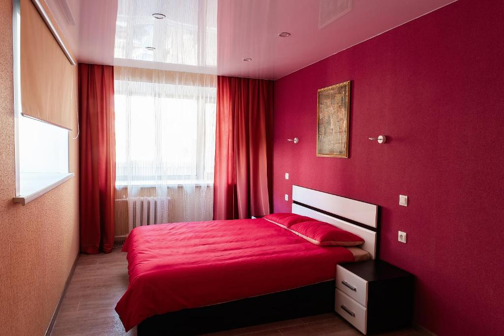 ヴォログダにあるApartment Na Leningradskoiの赤いベッドルーム(赤い毛布付きのベッド付)
