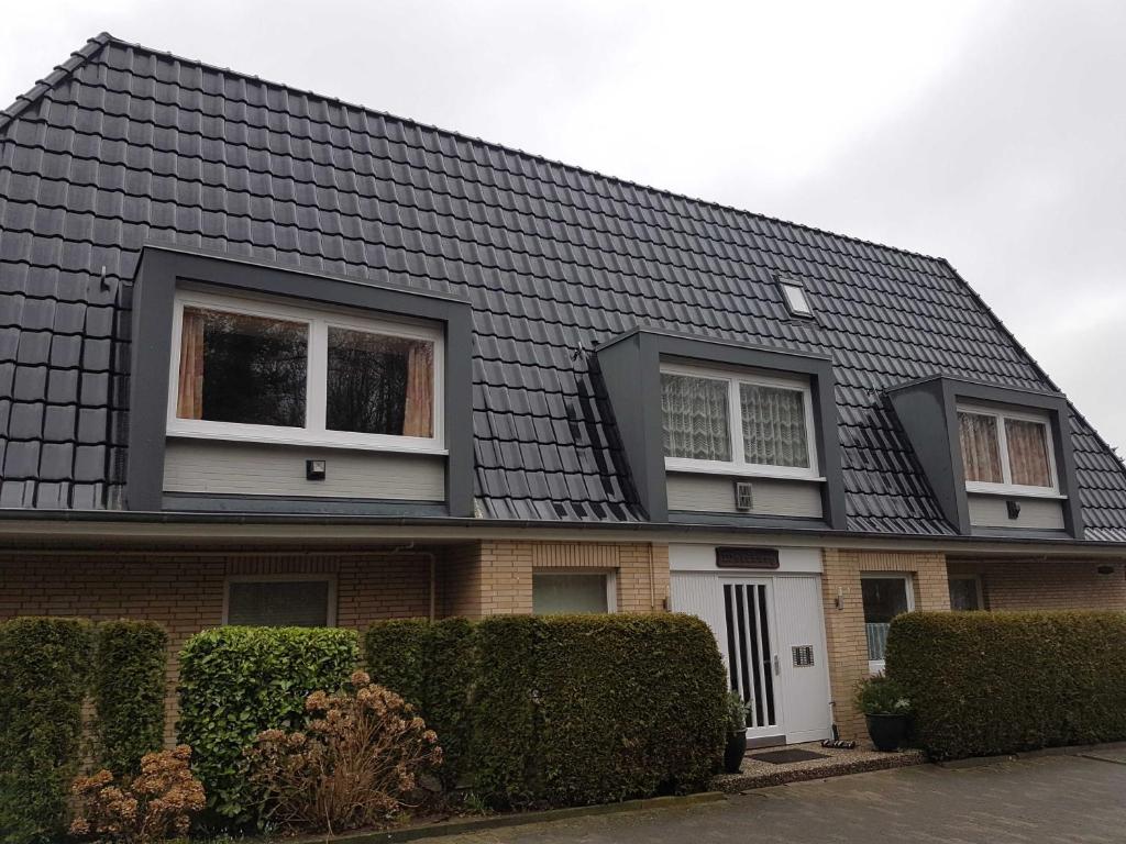 una casa con techo negro y 2 ventanas en Appartment Holiday, en Scharbeutz