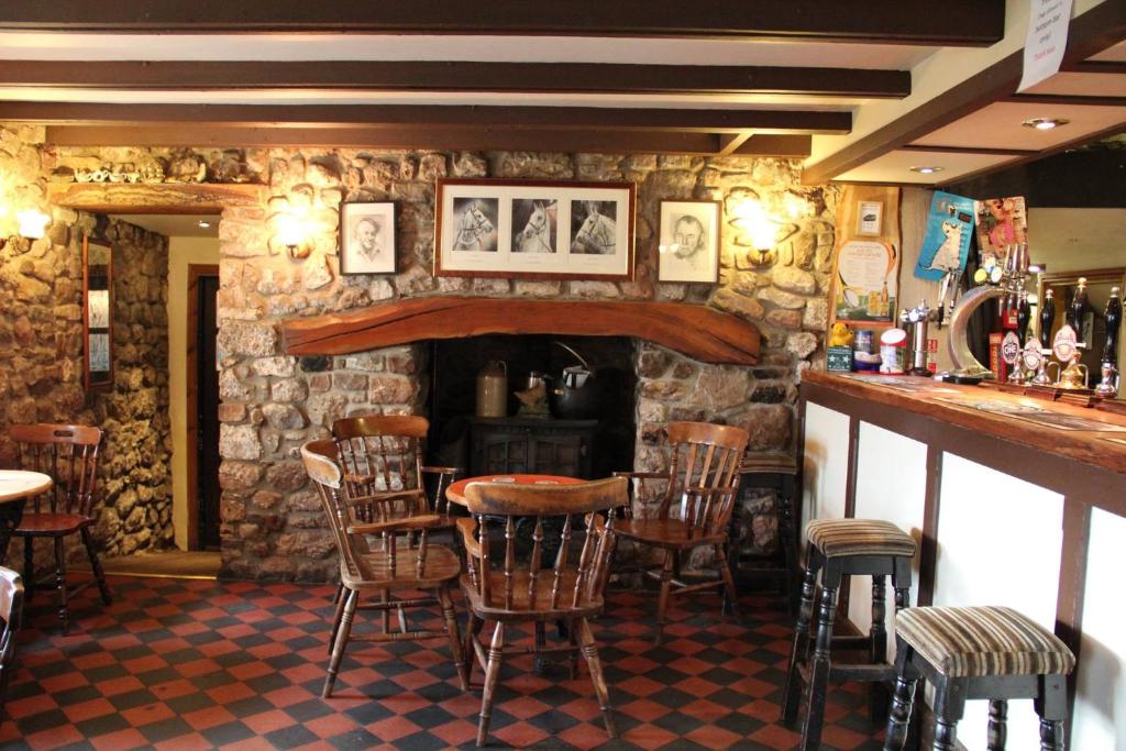 a bar with chairs and a fireplace in a restaurant at King's Head Inn in Llangennith