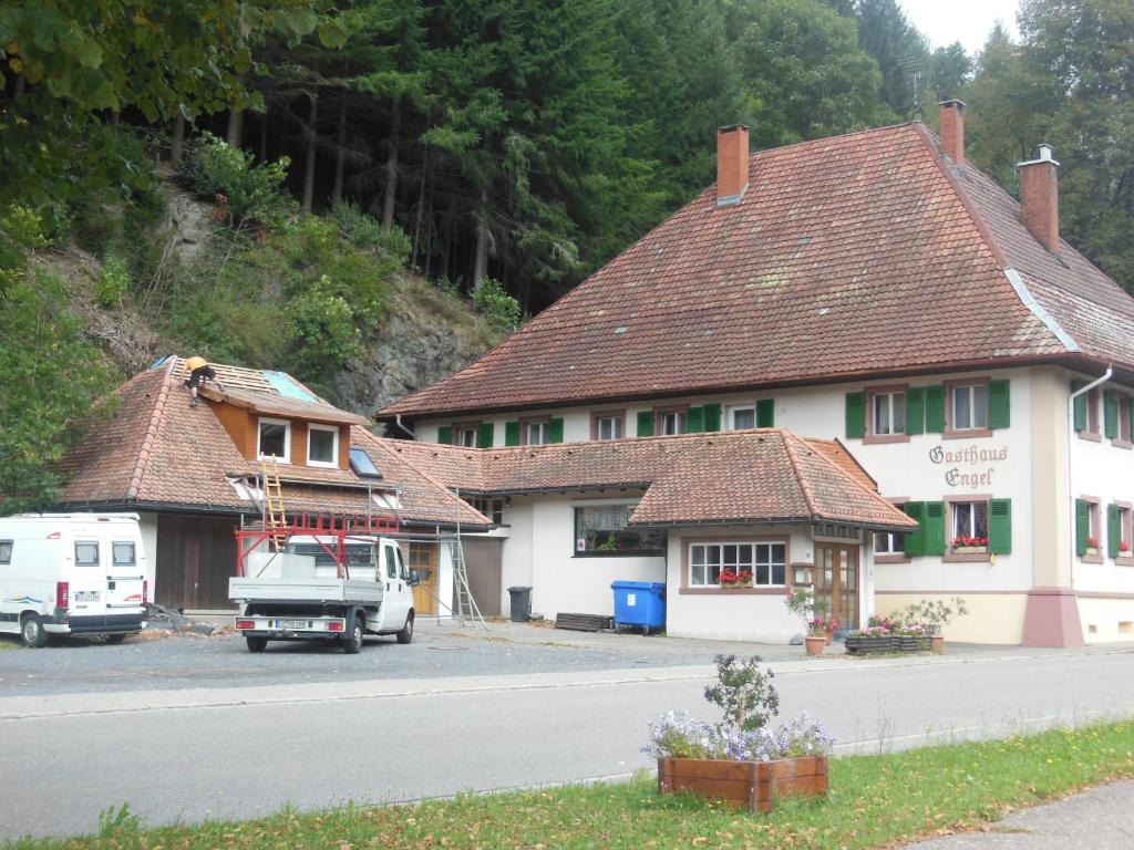 Utzenfeld的住宿－Haus Barnabas im Engel, Gasthaus Engel，停在前面的带货车的建筑