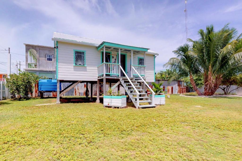 a house with a staircase leading up to it at Casa DV Cabanas in Caye Caulker