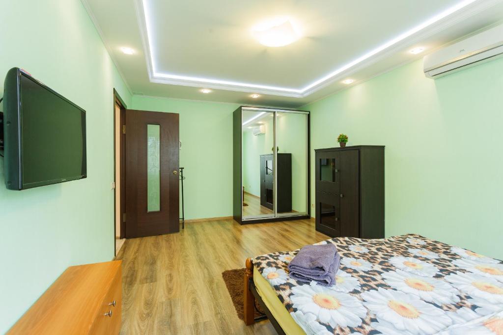 キーウにあるКвартира рядом з метро Мінськаのベッドルーム1室(ベッド1台、壁掛けテレビ付)