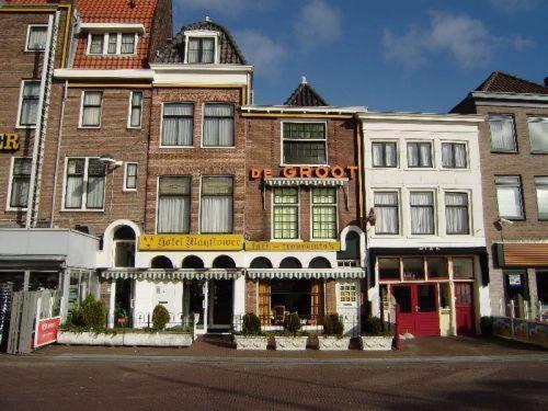 a large brick building with a store on a street at Hotel Mayflower in Leiden