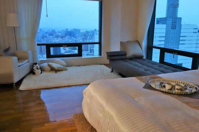 a living room with a bed and a couch at Corner Inn in Taichung