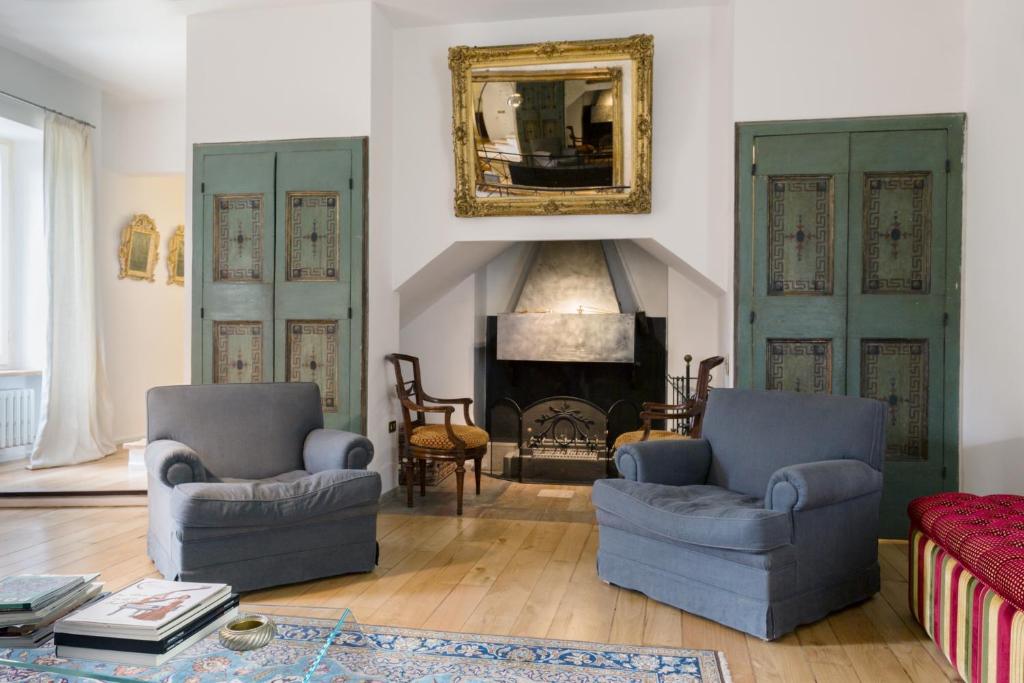 un soggiorno con 2 sedie e un camino di Appartamento Il Giglio a Spoleto