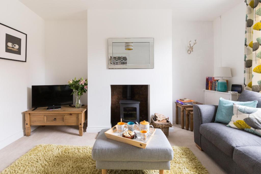 a living room with a couch and a fireplace at Baker's Dozen in Stratford-upon-Avon