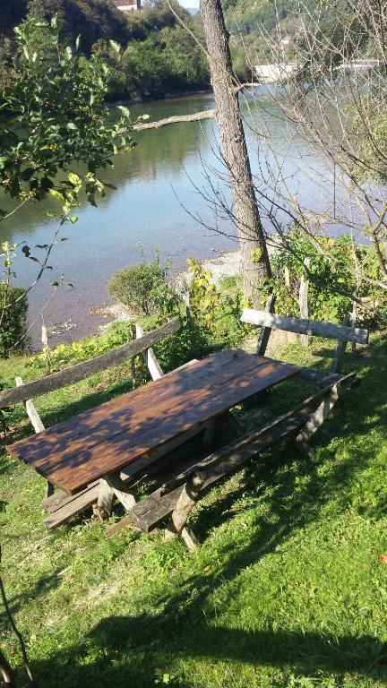 a wooden picnic table next to a tree next to a river at Vikendica pored Drine Foča in Handići
