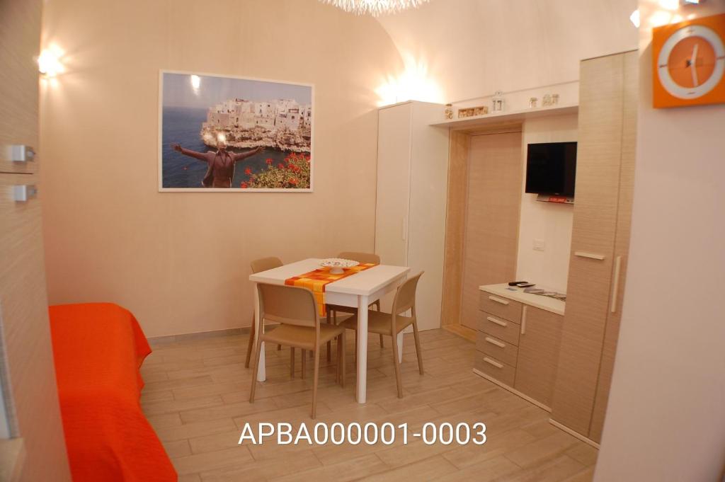 une petite chambre avec une table et une cuisine dans l'établissement GIUAMAR casa vacanza, à Polignano a Mare