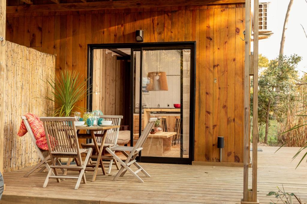 a patio with a table and chairs on a wooden deck at Yaku Beach in José Ignacio