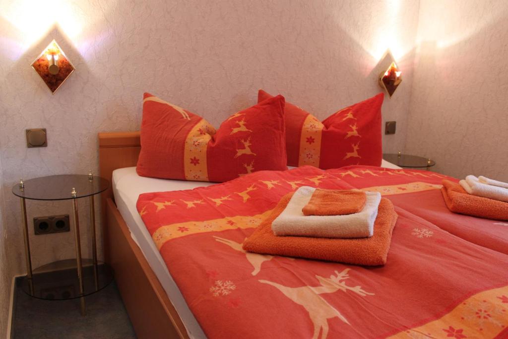 ein Schlafzimmer mit einem roten Bett mit roten Kissen in der Unterkunft Puppenstübchen in Wernigerode