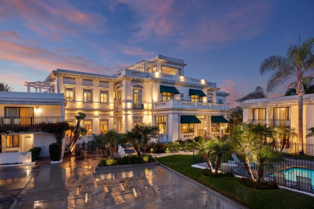 a large white building with palm trees in front of it at Glorietta Bay Inn in San Diego