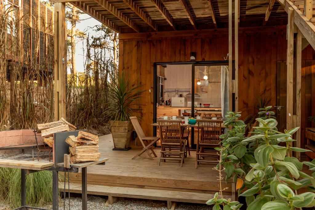 une terrasse en bois avec une table et des chaises. dans l'établissement Zulu Beach, à José Ignacio