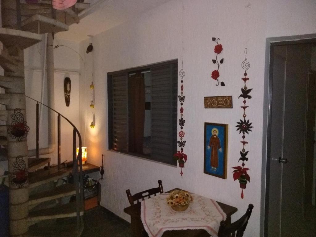 um quarto com uma mesa e algumas decorações na parede em Quartos no centro de Itu - Hospedagem Elizabeth em Itu