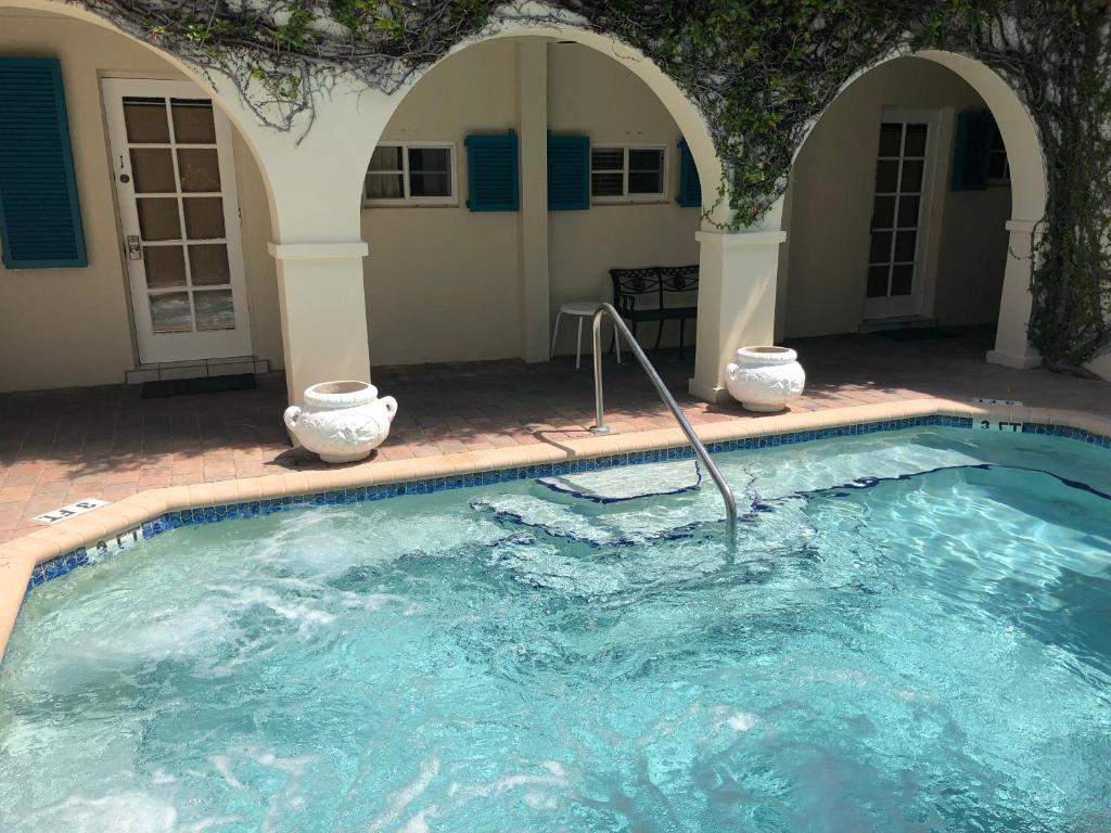 a swimming pool with two white vases in it at Courtyard Villa Hotel in Fort Lauderdale