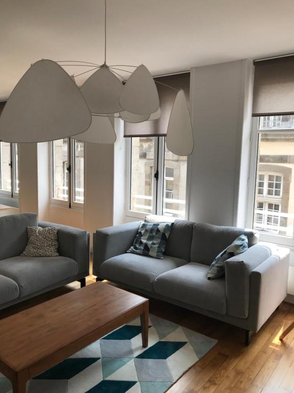 a living room with two couches and a coffee table at Appartement de charme in Saint Malo