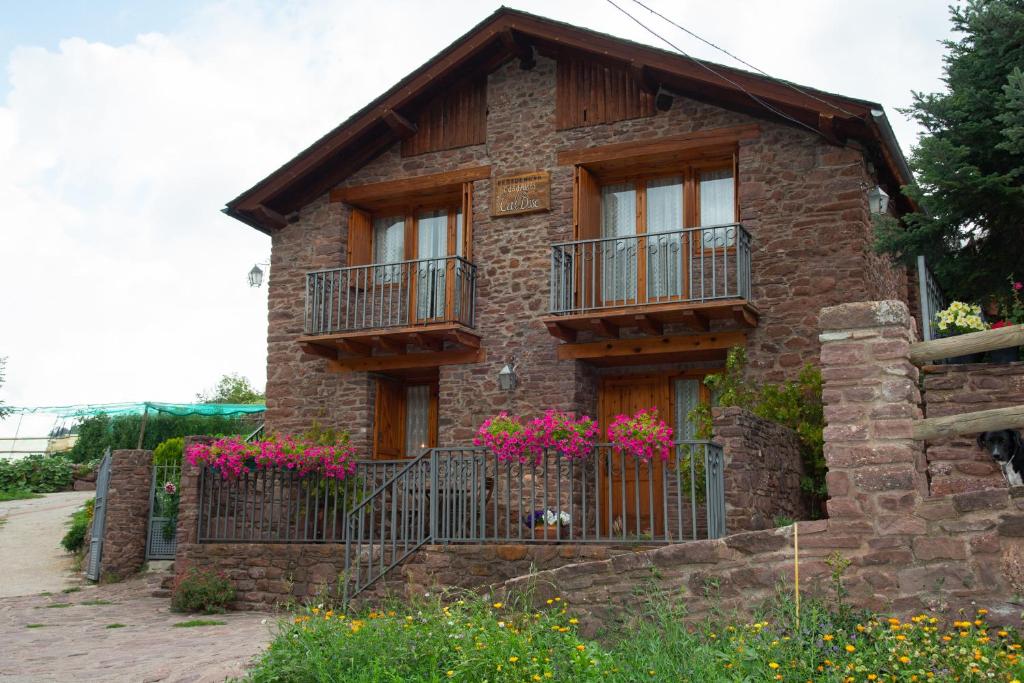 une maison en briques avec des balcons et des fleurs devant elle dans l'établissement Casa Rural Cal Bosch, à Llagunes
