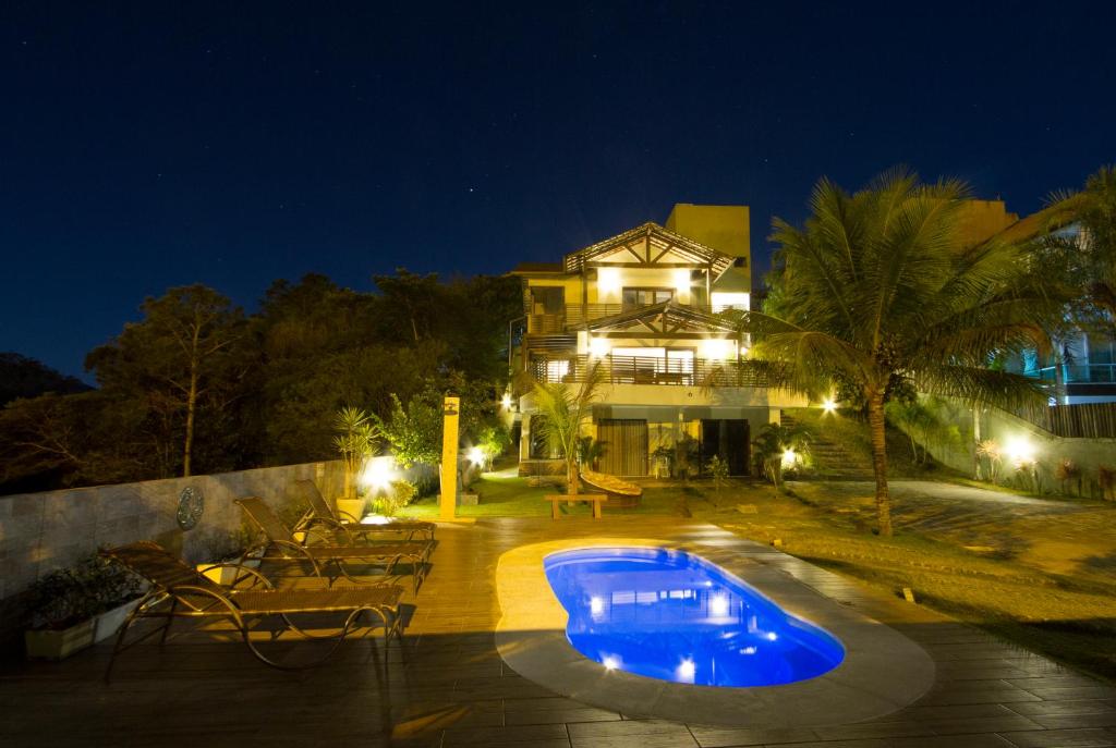 a swimming pool in front of a house at night at Canto Da Mole in Florianópolis