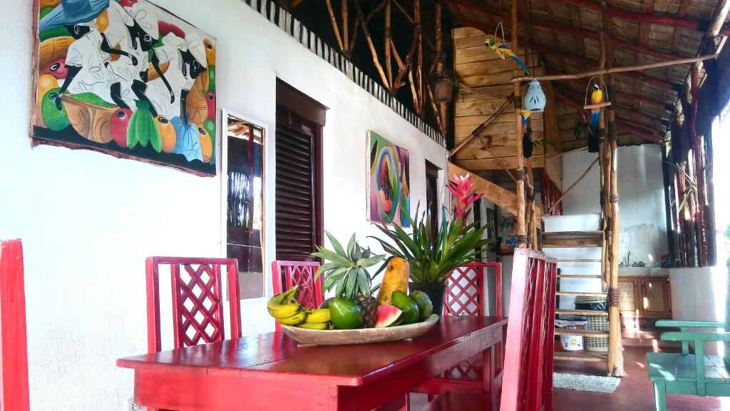 a red table with a bowl of fruit on it at Hostel La Ballena Backpacker in Las Galeras