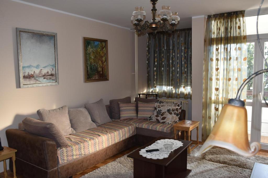 a living room with a couch and a table at Prizma in Tošin Bunar