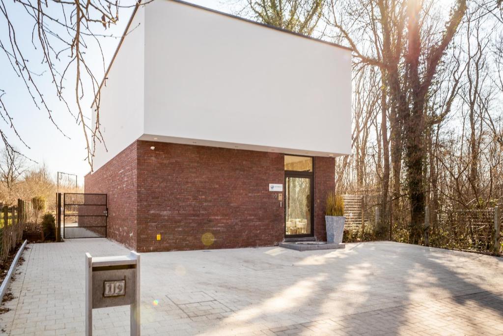 
a white brick building with a black door at Zen Your Life in Groot-Bijgaarden
