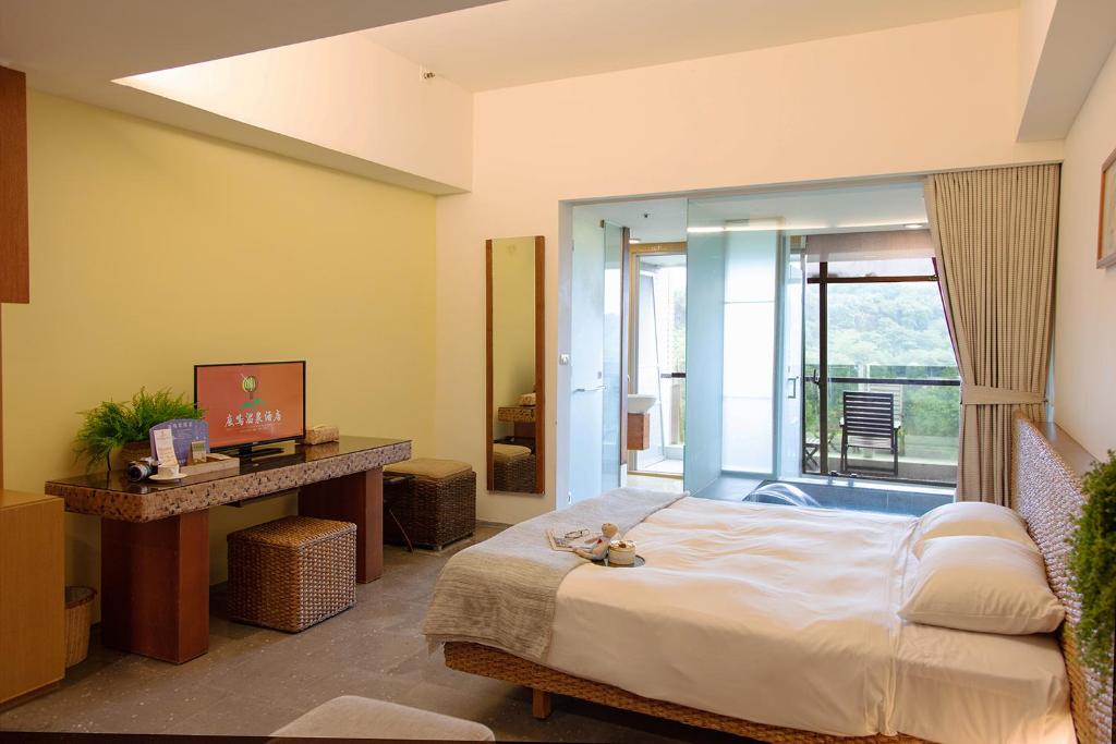 a bedroom with a large bed and a balcony at Luminous Hot Spring Resort &amp; SPA in Luye