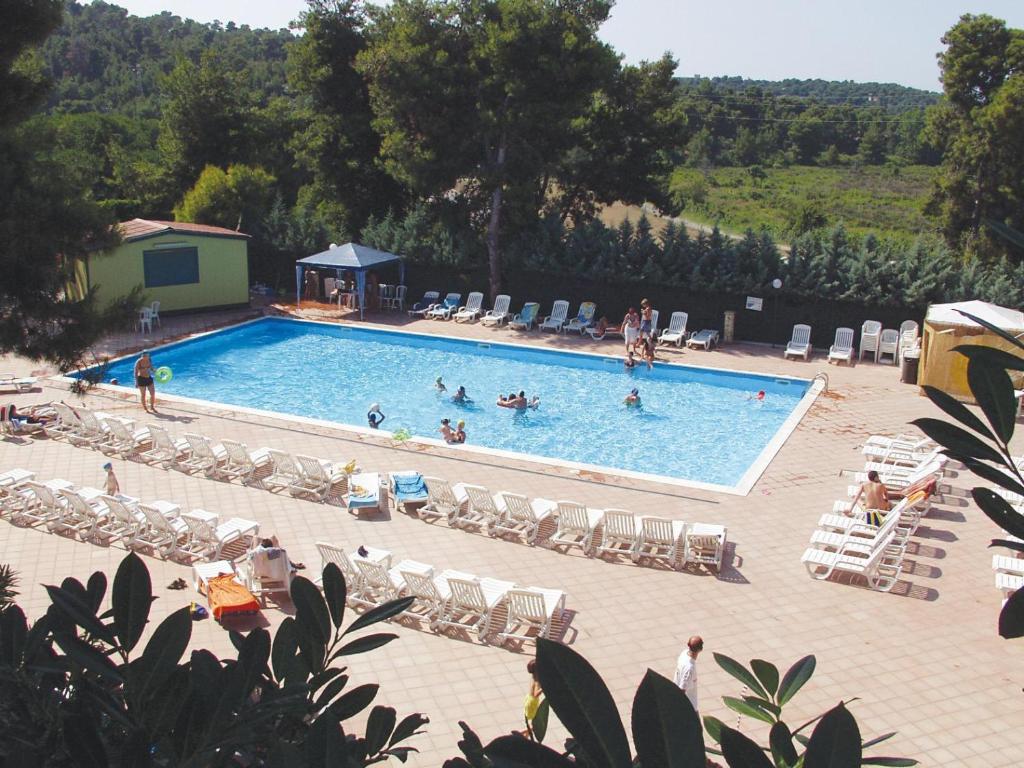 a large swimming pool with people swimming in it at Villaggio Club Baia di Paradiso in Peschici