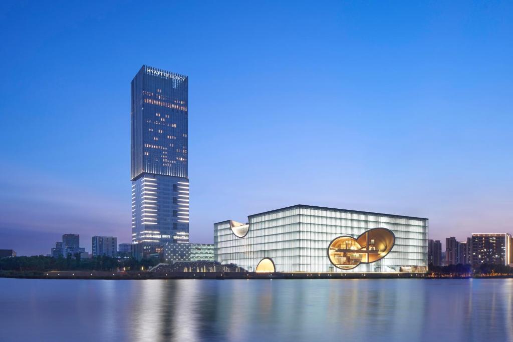un gran edificio con un cartel en él junto a una ciudad en Hyatt Regency Shanghai Jiading, en Jiading