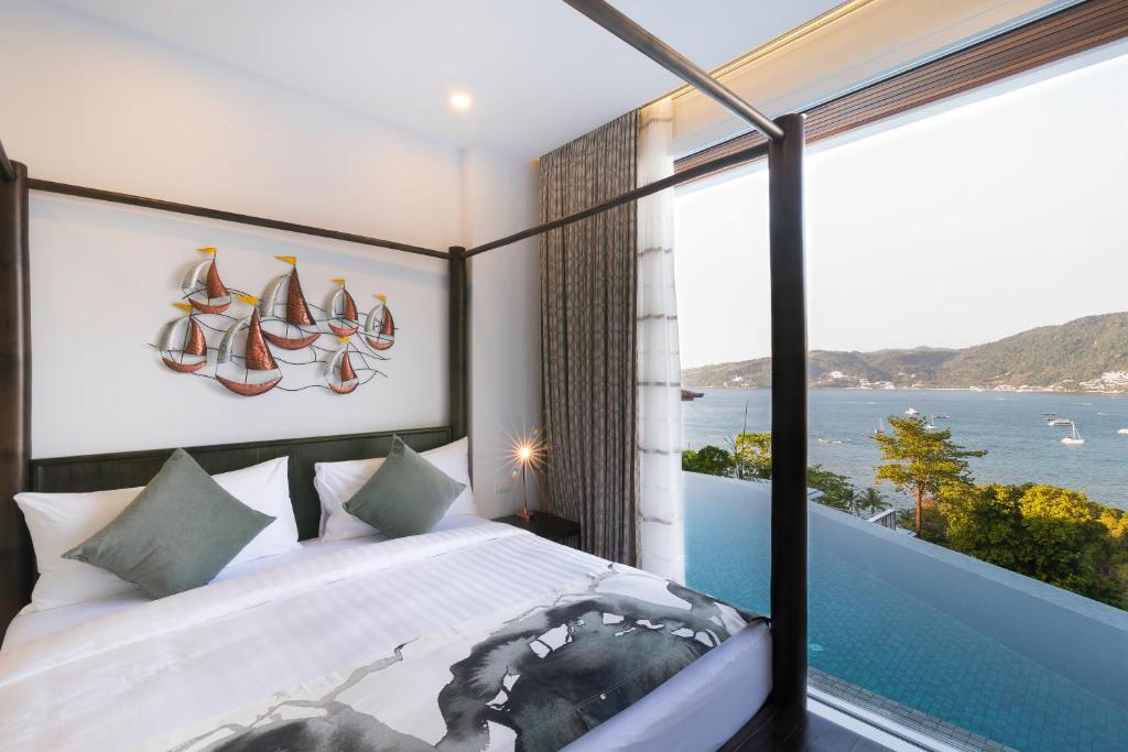 a bedroom with a bed with a view of the ocean at Jirana Patong in Patong Beach