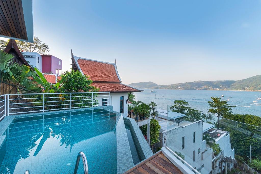 a swimming pool on top of a building with a view of the water at Jirana Patong in Patong Beach
