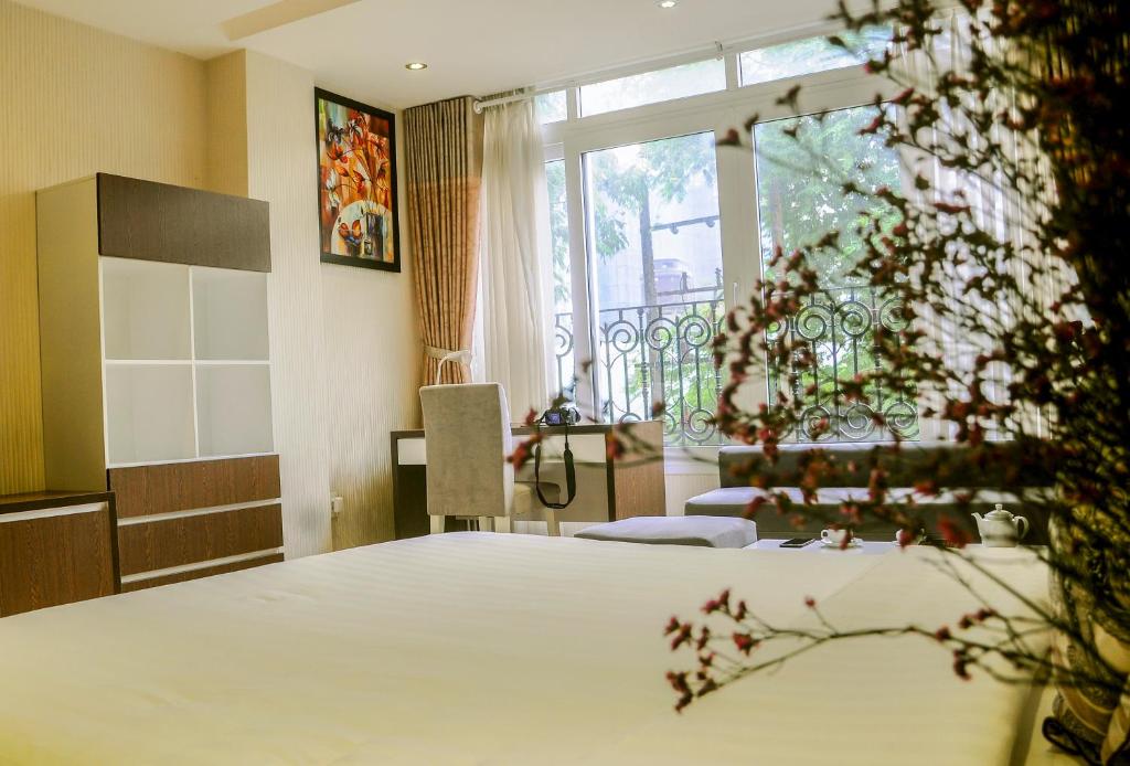 a bedroom with a bed and a large window at Sunny Serviced Apartment in Ho Chi Minh City