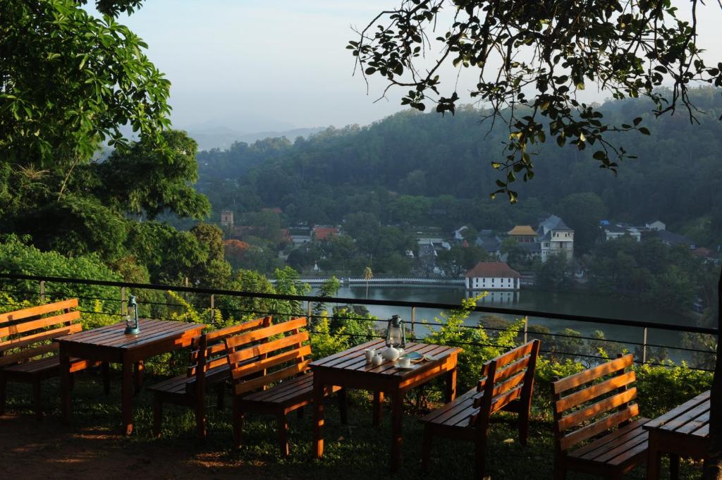 a table and chairs with a view of a valley at Hotel See Kandy in Kandy